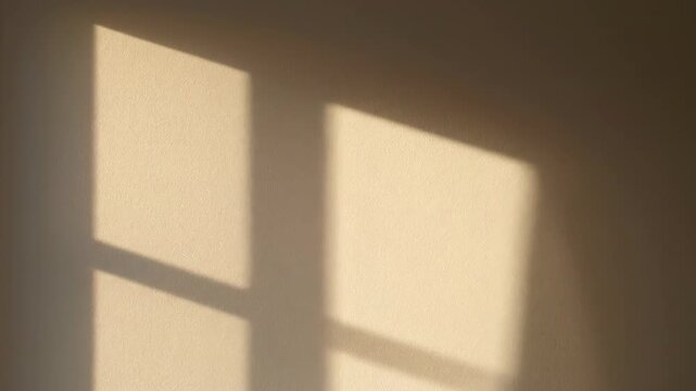 Sunlight moving across minimalist wall. Soft sunlight slowly moves across a minimalist living room wall, creating calm shifting shapes and subtle warmth.