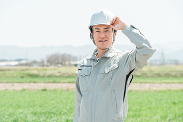 Middle-aged workers, craftsmen and site supervisors in work clothes standing in a rural rice field