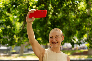 Woman taking selfie with smartphone in park