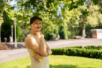 Mature woman smiling in park holding a smartphone