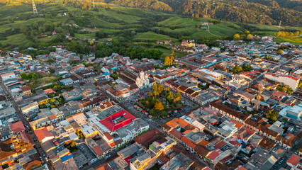 Fototapeta premium A vibrant aerial view of Filandia showcasing colorful rooftops, greenery in the background, and a church in the town center.