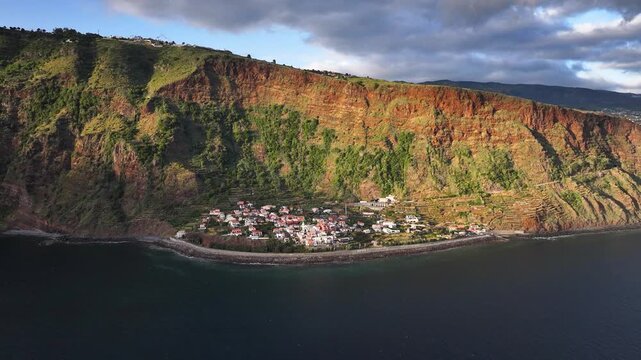 Jardim do Mar seaside village nestled below steep cliff on Madeira coast, aerial