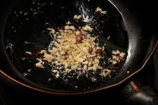 ニンニクと唐辛子をオリーブオイルで炒める様子