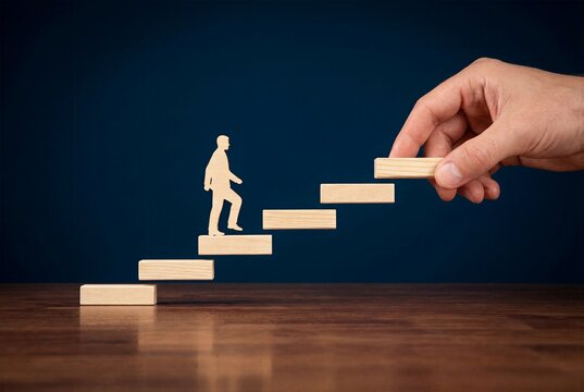 Hand building a wooden staircase path one step ahead of a walking figure, representing career planning, strategic foresight, and paving the way for future growth
