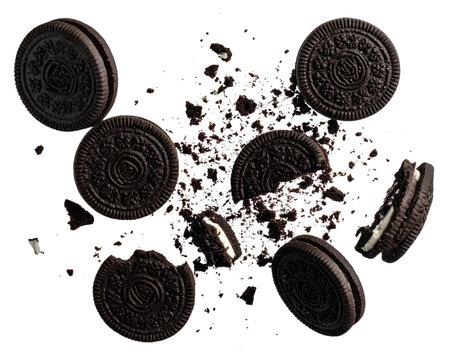 Scattered chocolate cookies with cream filling on transparent background isolated