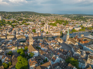 Fototapeta premium High angle aerial view of Zurich old town highlighting Fraumunster, Grossmunster and St Peter Church beside the Limmat River with Lake Zurich during a clear summer day in Switzerland