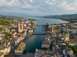 Obraz premium Aerial cityscape of Zurich with the Limmat River crossing the historic center toward Lake Zurich, featuring Fraumunster, Grossmunster and St Peter Church