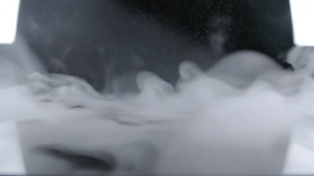 Swirling, opaque white smoke against a dark background, softly illuminated