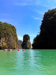 Experience the tropical paradise of Phi Phi Island, Thailand, where turquoise water meets a white sand beach and majestic rock mountains in a stunning Krabi lagoon landscape