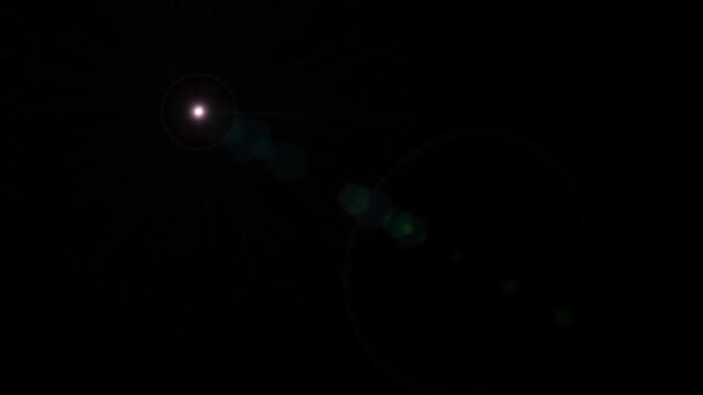 Light with pinkish-purple halo and green flare on black background