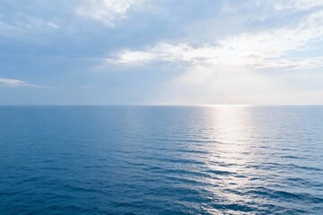 Obraz premium Ocean horizon with sunlight and clouds
