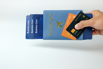 A hand holding a passport holder, boarding pass, and credit card on a clean white background. Perfect for fintech, banking, airline services, corporate travel, and global mobility, cashless, holiday