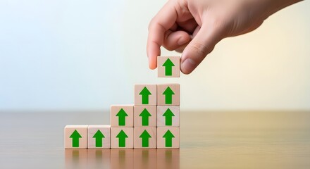 Hand builds rising chart with green up arrows on wooden blocks