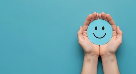 Hands holding a blue paper smiling face on teal background
