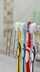 Hanging toothbrush on holder in bathroom, daily oral hygiene routine concept