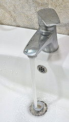 Close up of water flowing from sink faucet in modern bathroom