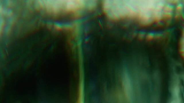 Defocused flicker background. Optical glow. Green color rainbow glare shadow reflection on visual illuminated art bokeh abstraction.