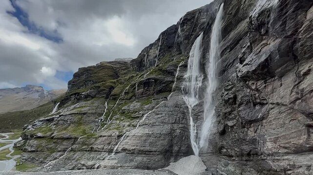 Dramatic waterfall from rocky mountain cliff, Earnslaw Burn hiking track in New Zealand