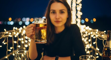 Woman enjoying a beer outdoors at night with festive lights.