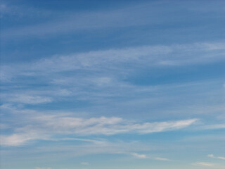 Obraz premium Blue sky developing white cirrus clouds, creating a natural background with soft texture and open space, providing a serene outdoor view from port washington, new york