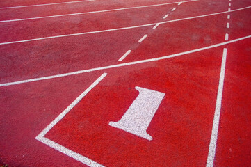 Red running track with lane number 1 in focus, curved layout ideal for race start, sprint, or sports training visuals.