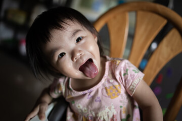 Adorable baby girl is reaching for the camera with a playful expression on her face