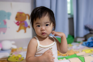 A curious toddler, gazing directly at the camera with a thoughtful expression.