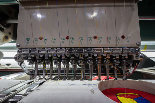 Close-up of Worker hand putting embroidery thread into embroidery needle at textile Industry at Garment Manufacture