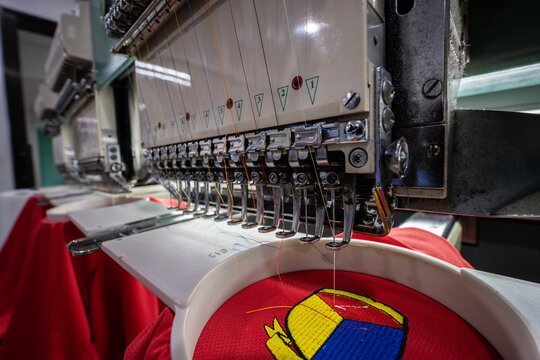 Close-up of Worker hand putting embroidery thread into embroidery needle at textile Industry at Garment Manufacture