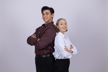 Confident man and woman standing back to back in studio