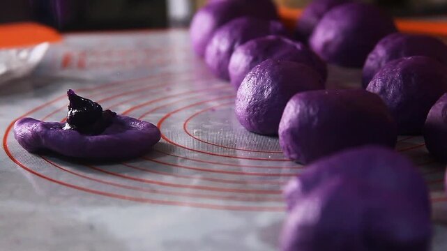 Filipino food called Ube cheese pandesal or bread with yam jam and cheese filling being prepared to be baked.