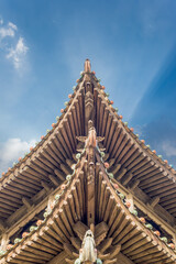 Obraz premium Upturned Eaves of Traditional Chinese Wooden Architecture Against a Clear Blue Sky