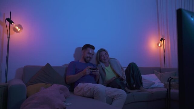 Couple Playing Video Games Together in Cozy Living Room at Night