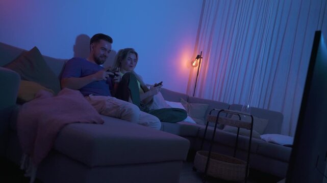 Couple Playing Video Games Together in Cozy Living Room at Night
