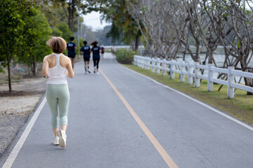 Obraz premium Woman running outdoors on a road in a natural environment. Concept of fitness