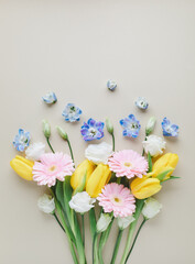 Fototapeta premium Fresh bouquet of beautiful spring flowers top view. Greeting card for International Women Day or Mother day background. Flat lay.