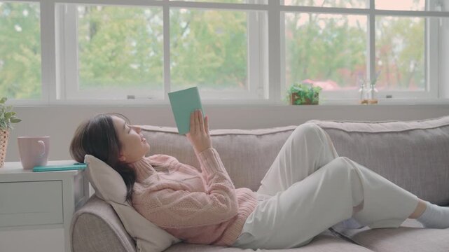 ソファで本を読む女性