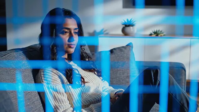 Woman relaxing on sofa indoors behind abstract grid pattern overlays