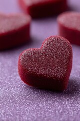 close-up of a heart-shaped red velvet candy, a valentine's day background with a dark purple color