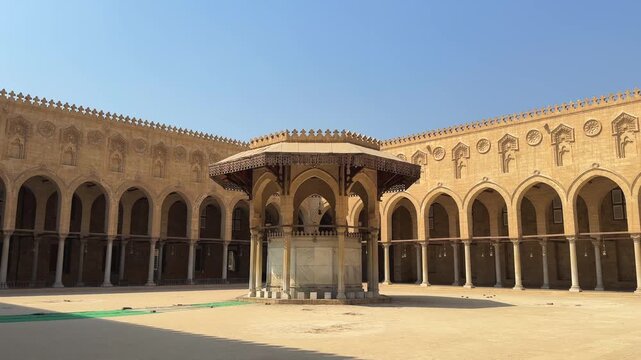 Inner courtyard of a historic mosque in Islamic Cairo with arches and ablution fountain