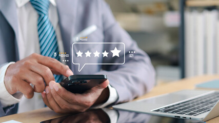 Businessman using smartphone to give five star rating and customer review. Concept of online...