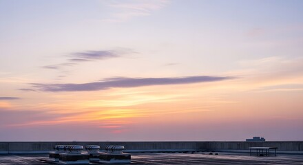 Obraz premium Tranquil urban sky at dusk with soft pastel colors painting the horizon over a city rooftop, capturing a peaceful moment as day transitions to night