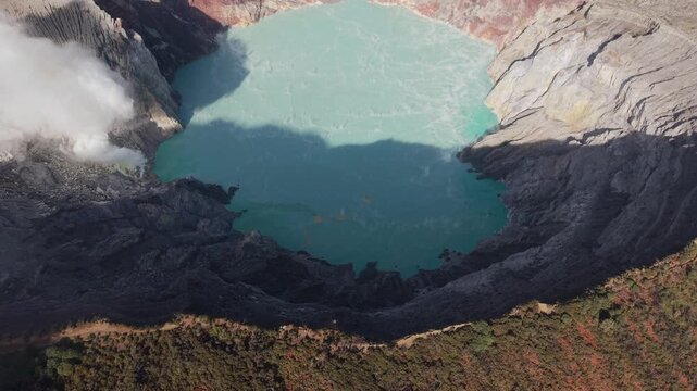 Aerial View of Ijen Volcano Crater Lake with Turquoise Acid Water, Sulfur Smoke and Mountain Landscape, East Java, Indonesia.