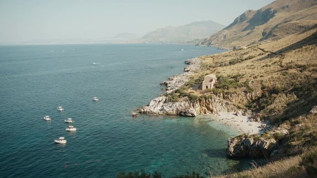 Coastal cove in Zingaro Nature Reserve Sicily with boats and clear water