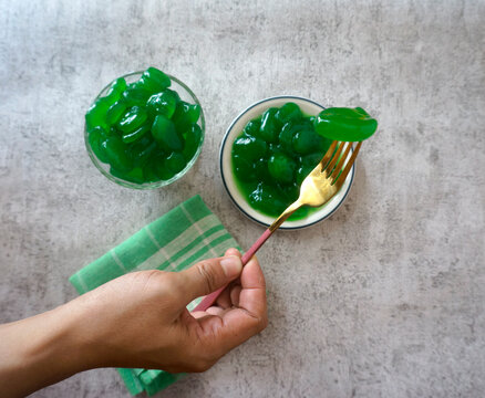 Selective Focus. Focus On Hand Holding Sugar Palm Fruit On Fork, With The Rest Of It On Plates As Background