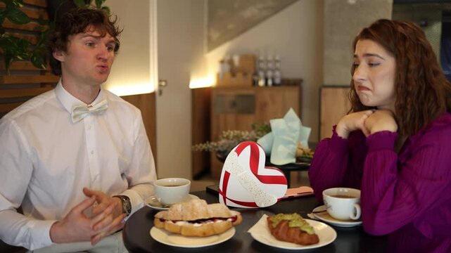 Awkward silence fills the cafe date as man talks nervously while woman looks unsure both sensing they may not like each other mismatch tension uncertain mood and hesitant emotion