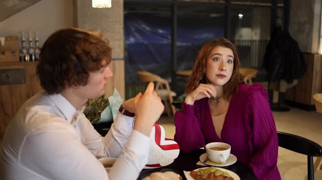 Man suggests intimate playful ideas during casual cafe date woman looks bored and unimpressed tension awkward mood modern dating discomfort emotional disconnect silence u