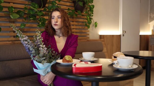 Young woman sits alone in cafe holding flowers showing how online era makes real life dating harder leaving people disconnected lonely and waiting for meaningful offline meetings
