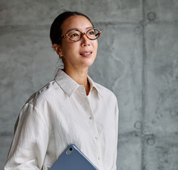 Portrait of a smart young businesswoman, student, teacher or coach holding a tablet