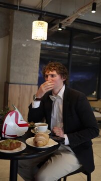 Vertical screen exhausted man arrives to the date after many work shifts and sleepless nights barely staying awake yawning and struggling to focus while the atmosphere turns quietly awkward